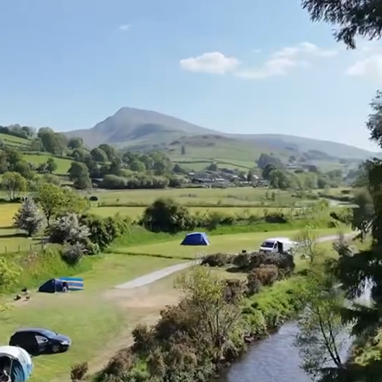 view of the mountains in the back ground and the campsite on  the river bed 